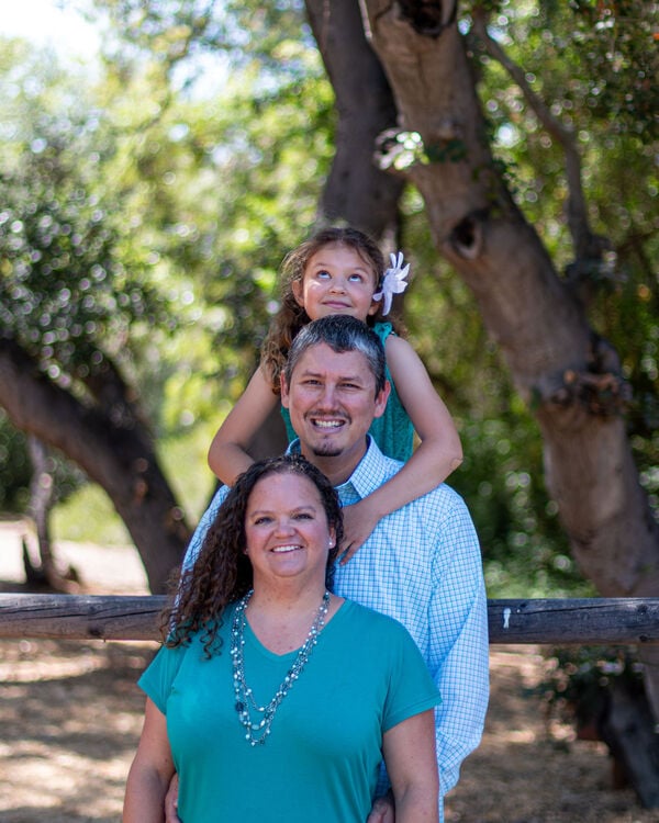 Simone and Richard, Angels Foster Family Network Resource Parents, with their daughter